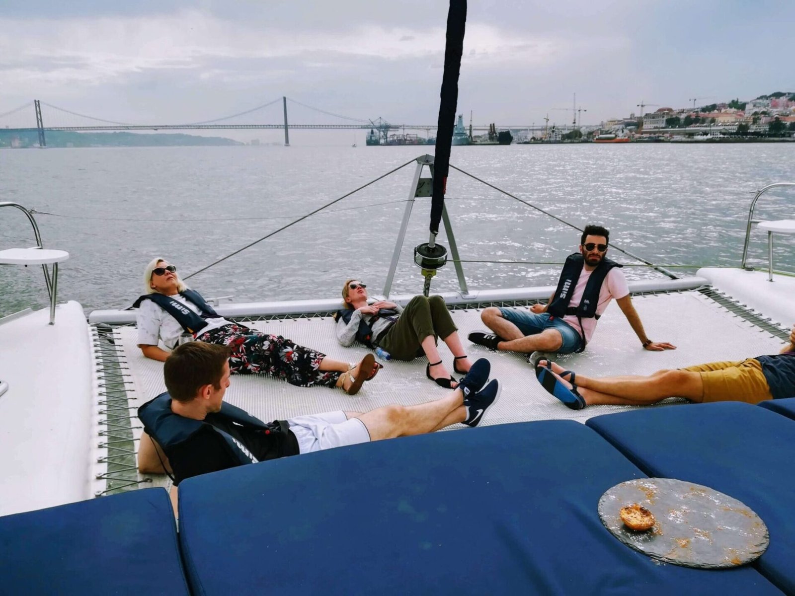Des personnes se détendant allongées sur le filet du catamaran