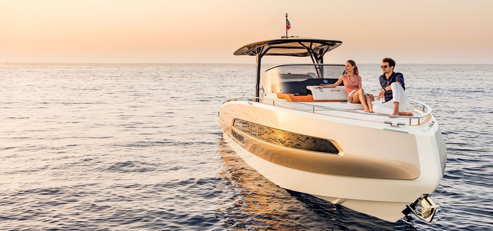 Yacht de luxe Invictus GT370 naviguant sur des eaux calmes au coucher du soleil, idéal pour des charters exclusifs à Lisbonne.